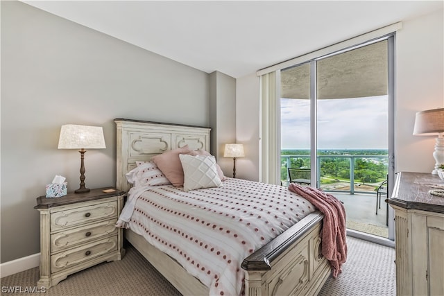 bedroom with expansive windows, light colored carpet, and access to exterior