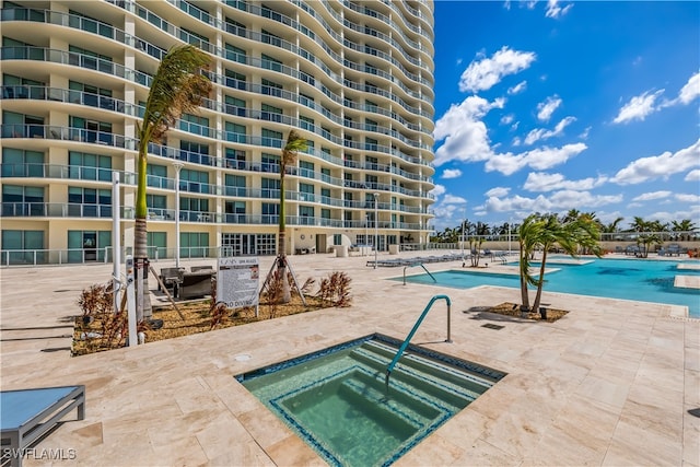 view of swimming pool featuring a community hot tub and a patio