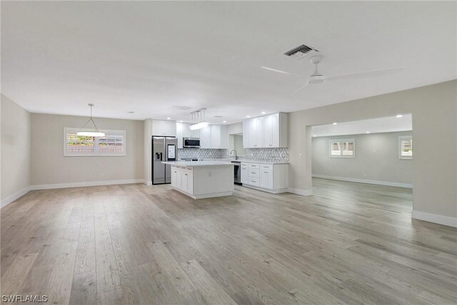 unfurnished living room featuring light hardwood / wood-style floors, sink, and ceiling fan