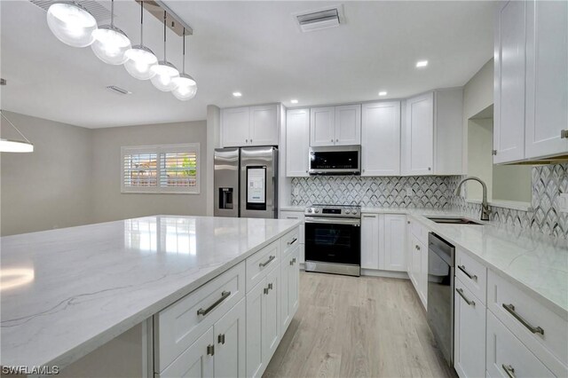 kitchen with decorative backsplash, stainless steel appliances, light hardwood / wood-style flooring, and sink