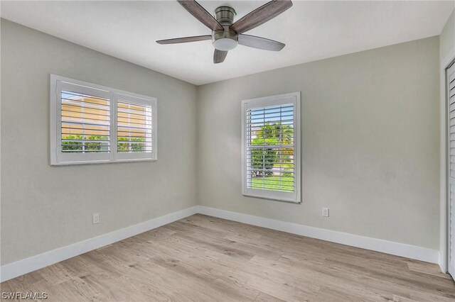 empty room with ceiling fan and light hardwood / wood-style flooring