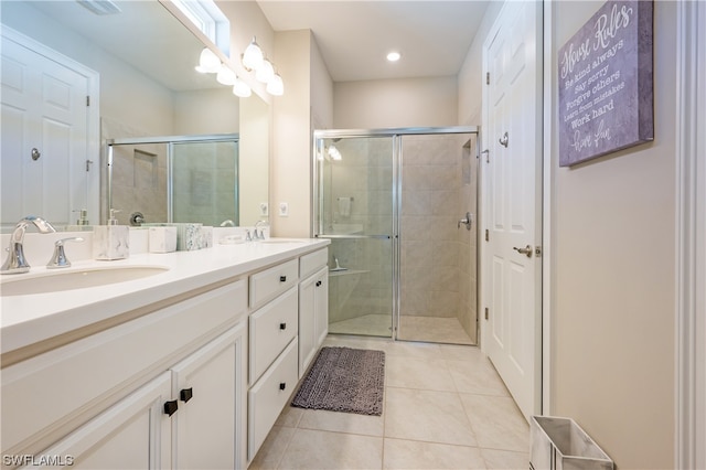 bathroom featuring double vanity, walk in shower, and tile patterned floors