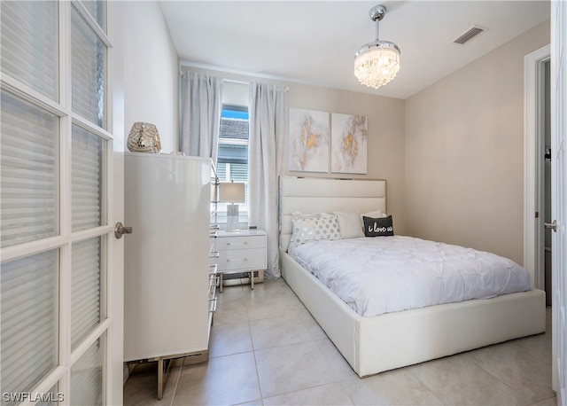 tiled bedroom featuring an inviting chandelier