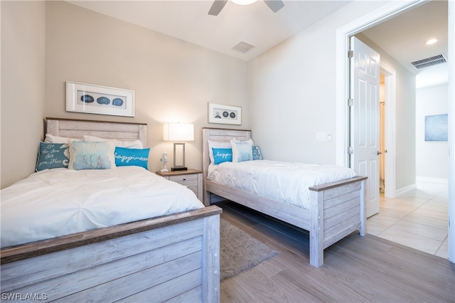 tiled bedroom featuring ceiling fan