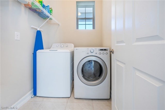 laundry area with light tile patterned flooring and washing machine and dryer