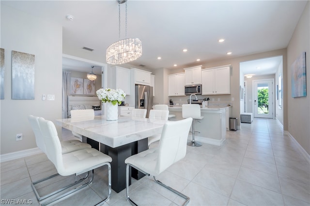 tiled dining space with sink and an inviting chandelier