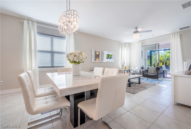 tiled dining area with ceiling fan with notable chandelier