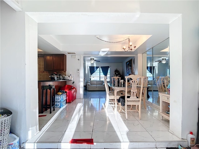 dining area featuring ceiling fan with notable chandelier