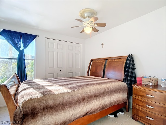 tiled bedroom featuring ceiling fan and a closet