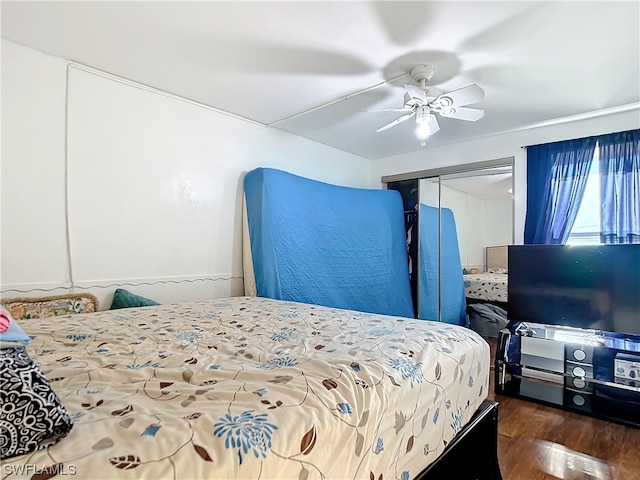 bedroom with dark hardwood / wood-style floors, ceiling fan, and a closet