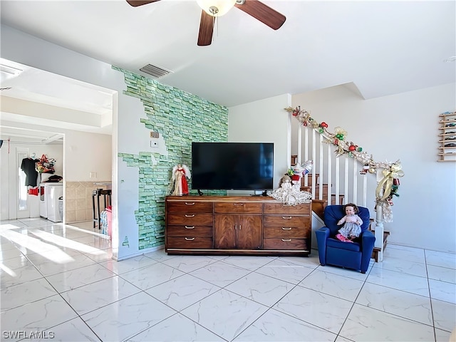 living room with ceiling fan and washer and dryer