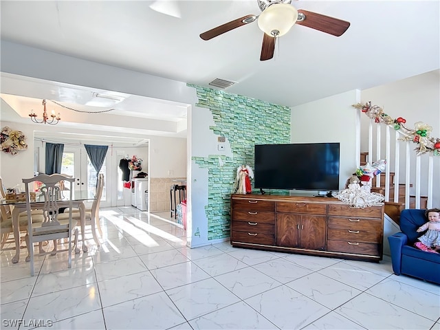 living room with ceiling fan with notable chandelier