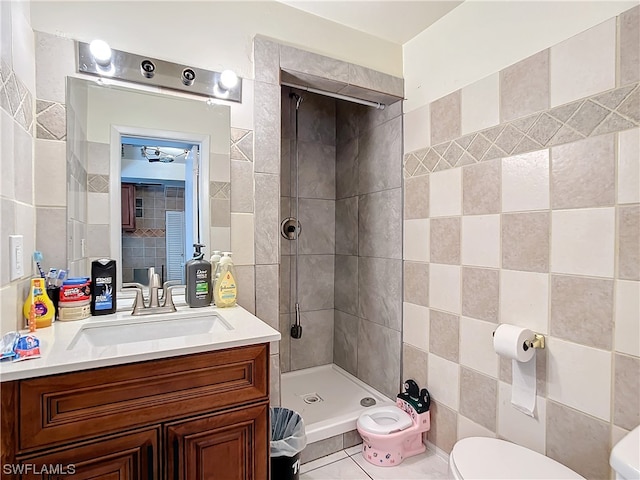 bathroom featuring a tile shower, tile patterned flooring, a bidet, vanity, and toilet