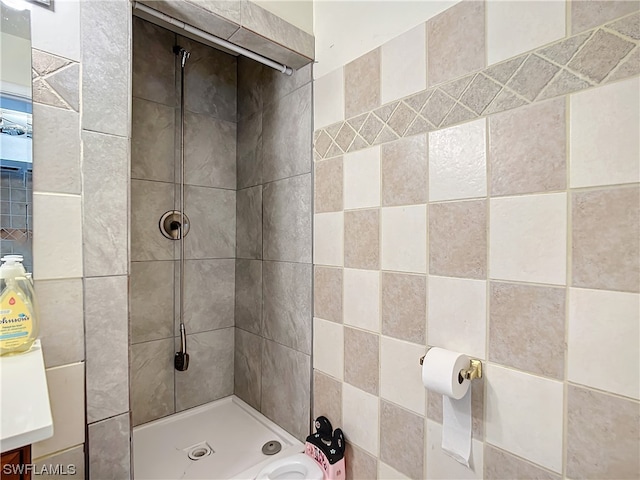 bathroom with vanity, tile walls, and a tile shower