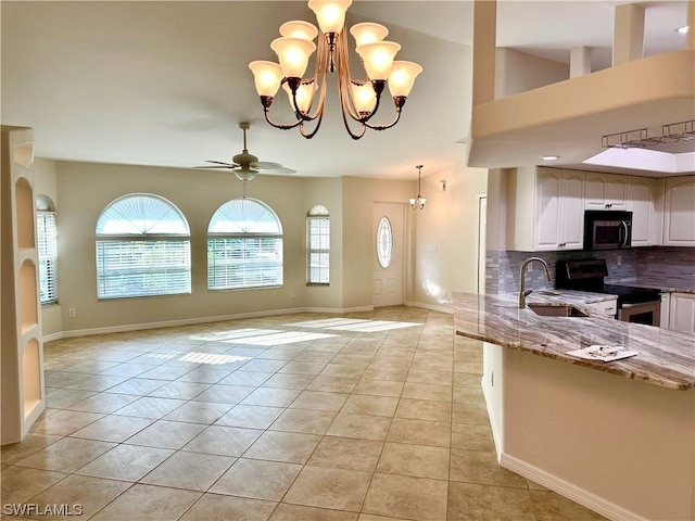 tiled foyer entrance featuring sink and ceiling fan with notable chandelier