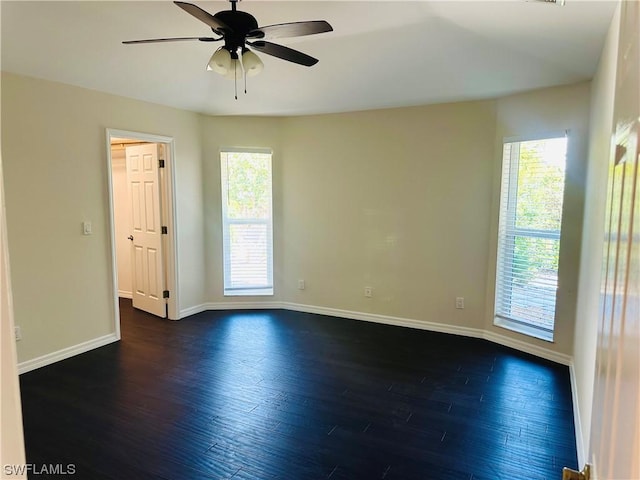 unfurnished room featuring ceiling fan, a wealth of natural light, and dark hardwood / wood-style flooring