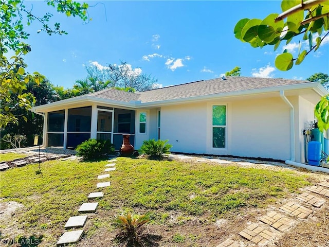 ranch-style home with a sunroom and a front lawn