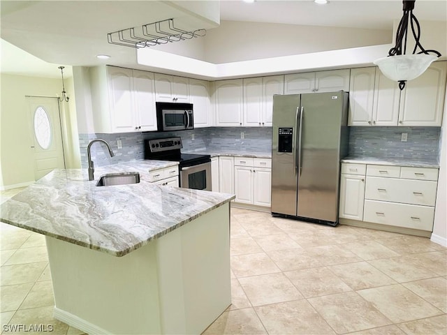 kitchen with lofted ceiling, sink, light stone counters, decorative light fixtures, and stainless steel appliances