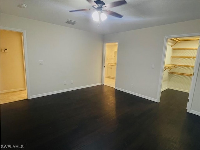 unfurnished room featuring dark wood-type flooring and ceiling fan