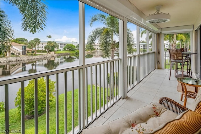 sunroom featuring a water view