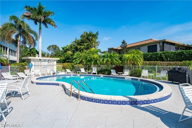 view of swimming pool featuring grilling area and a patio