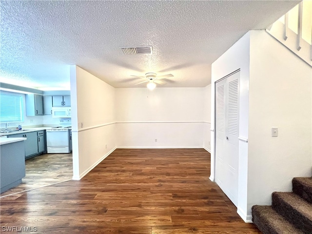 interior space featuring a textured ceiling, sink, ceiling fan, and dark hardwood / wood-style flooring