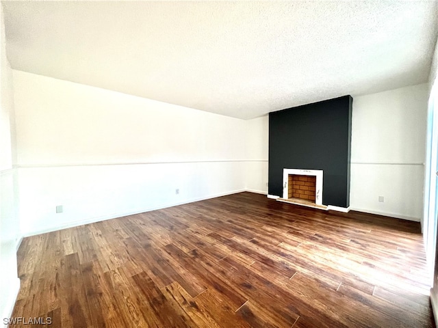 unfurnished living room featuring a textured ceiling, a fireplace, and hardwood / wood-style flooring