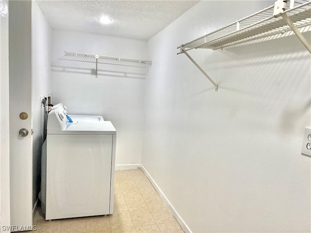 laundry area featuring washer and clothes dryer and a textured ceiling