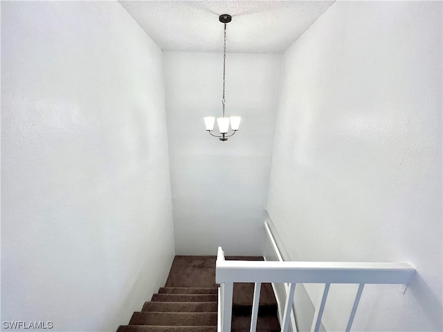 stairway featuring a textured ceiling