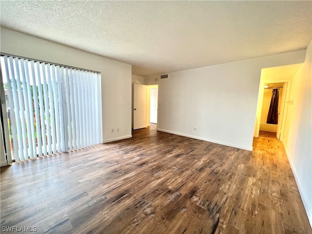 unfurnished room featuring a textured ceiling and hardwood / wood-style floors