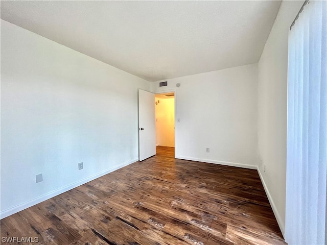 spare room with dark hardwood / wood-style flooring