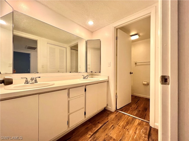 bathroom featuring wood-type flooring, a textured ceiling, and vanity