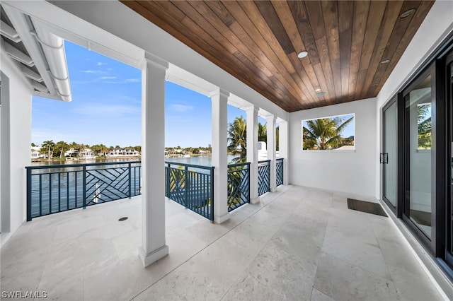 view of patio / terrace with a balcony and a water view