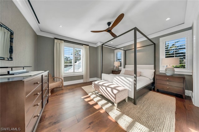 bedroom with dark hardwood / wood-style flooring, ceiling fan, and crown molding