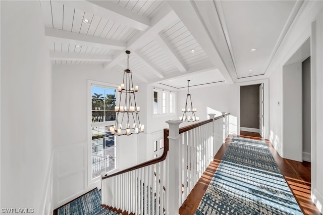 hall with dark wood-type flooring, vaulted ceiling with beams, and a chandelier