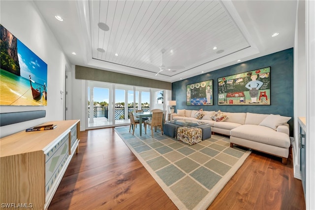 living room featuring dark wood-type flooring, french doors, a tray ceiling, and wooden ceiling