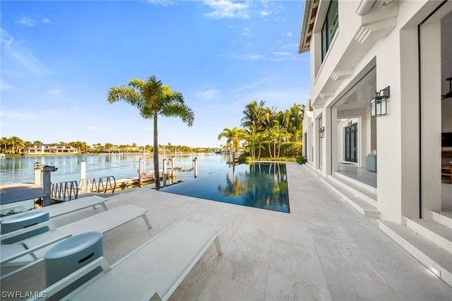 view of swimming pool with a patio and a water view