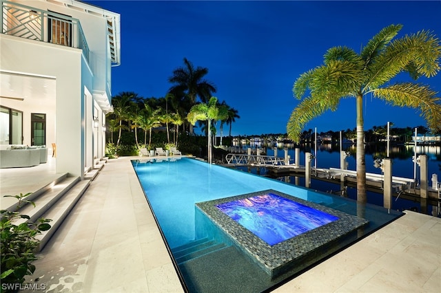 view of pool with a patio, an in ground hot tub, and a water view