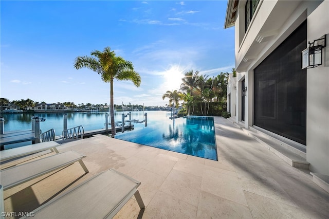 view of pool with a dock, a patio area, and a water view