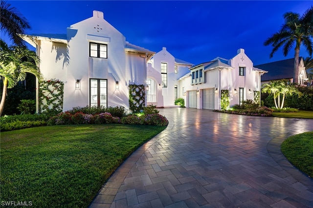 view of front of house with a garage and a yard