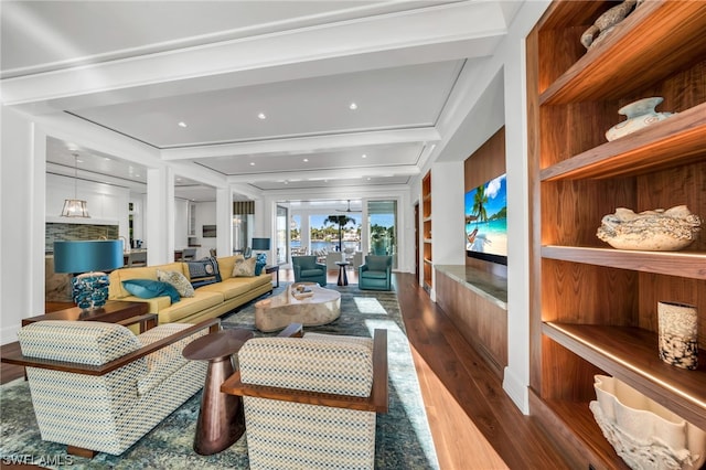 living room with hardwood / wood-style flooring, beamed ceiling, and built in features