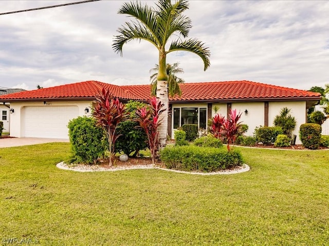 mediterranean / spanish house featuring a front yard and a garage