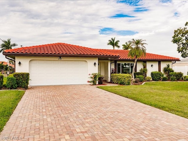 mediterranean / spanish house featuring a front yard and a garage