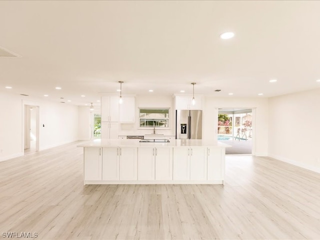 kitchen featuring white cabinets, stainless steel fridge with ice dispenser, light hardwood / wood-style flooring, and a wealth of natural light