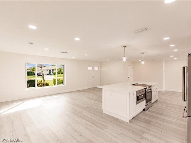 kitchen featuring pendant lighting, light hardwood / wood-style floors, a center island, stainless steel electric range oven, and white cabinets