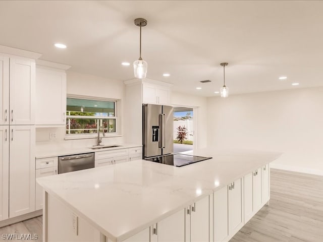 kitchen featuring pendant lighting, white cabinets, and appliances with stainless steel finishes