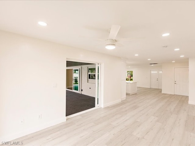 empty room featuring light hardwood / wood-style floors, ceiling fan, and a wealth of natural light