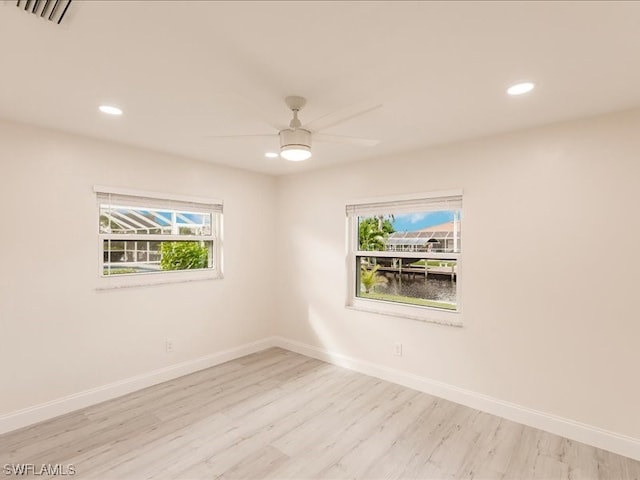 spare room with ceiling fan and light wood-type flooring