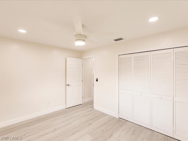 unfurnished bedroom with light hardwood / wood-style floors, a closet, and ceiling fan