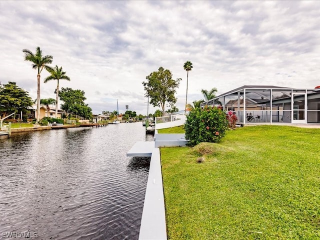 exterior space with glass enclosure, a water view, and a lawn